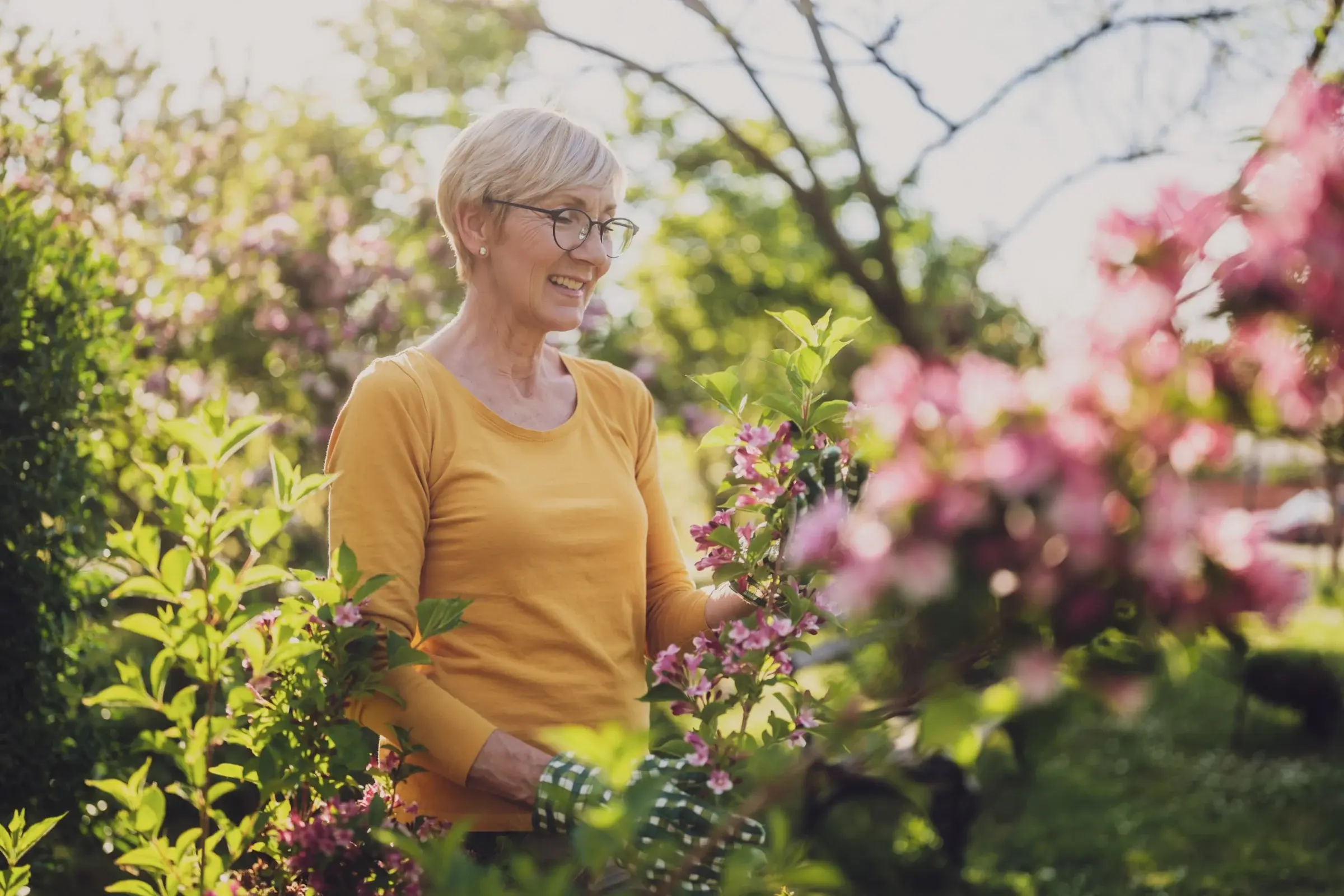 Gardener enjoying flowering plants in a garden